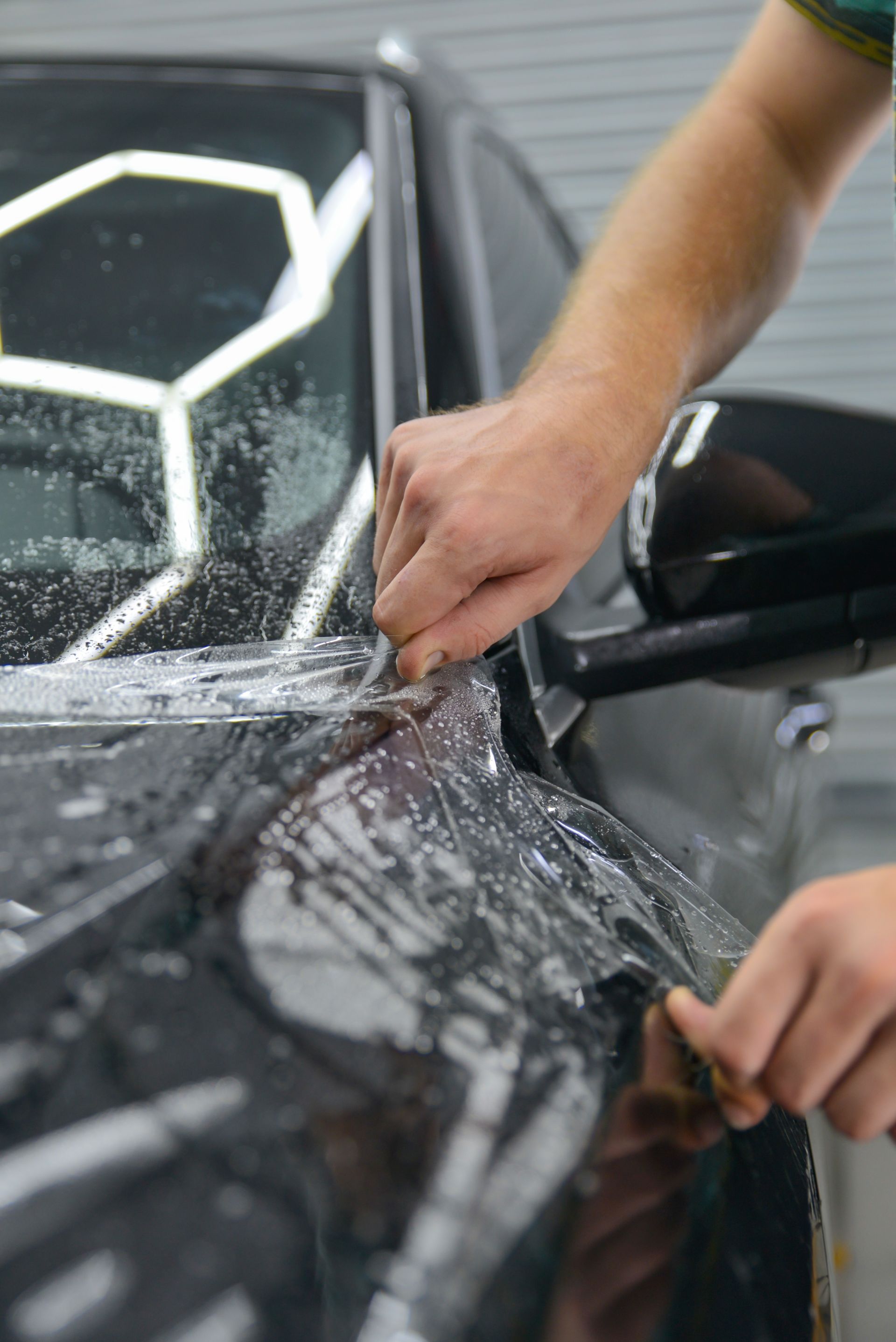 Paint protection film being applied to a vehicle headlight
